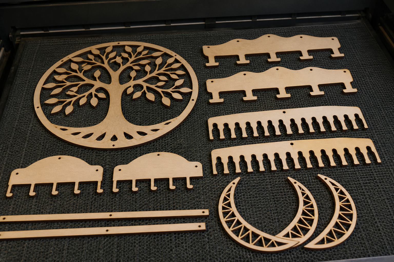 Laser-cut wooden jewelry hanger parts after cutting